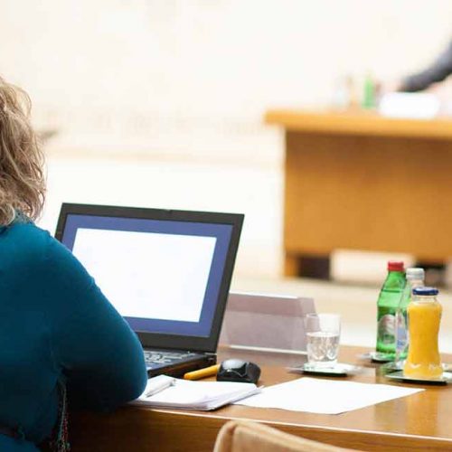 Woman sitting in front of laptop during meeting