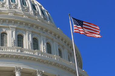 U.S. flag stand in front of U.S. Capital building dome