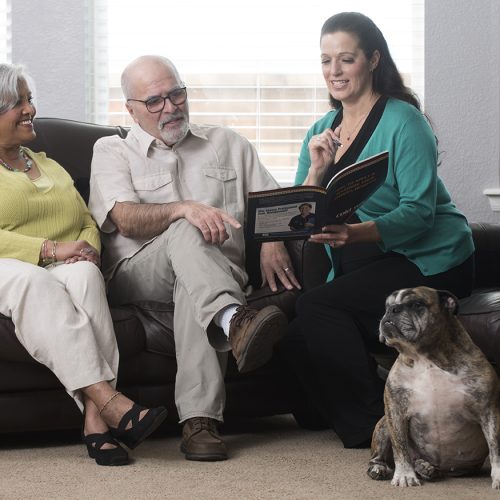 Adult child looking at brochure with parents and dog