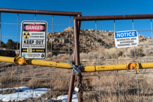 locked fence with "keep out" signs with mountain in the background