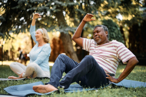 man and woman doing yoga outside