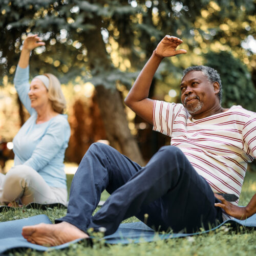 man and woman doing yoga outside