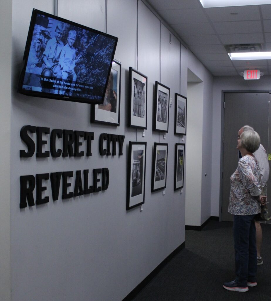 Museum patrons looking at photos on a wall