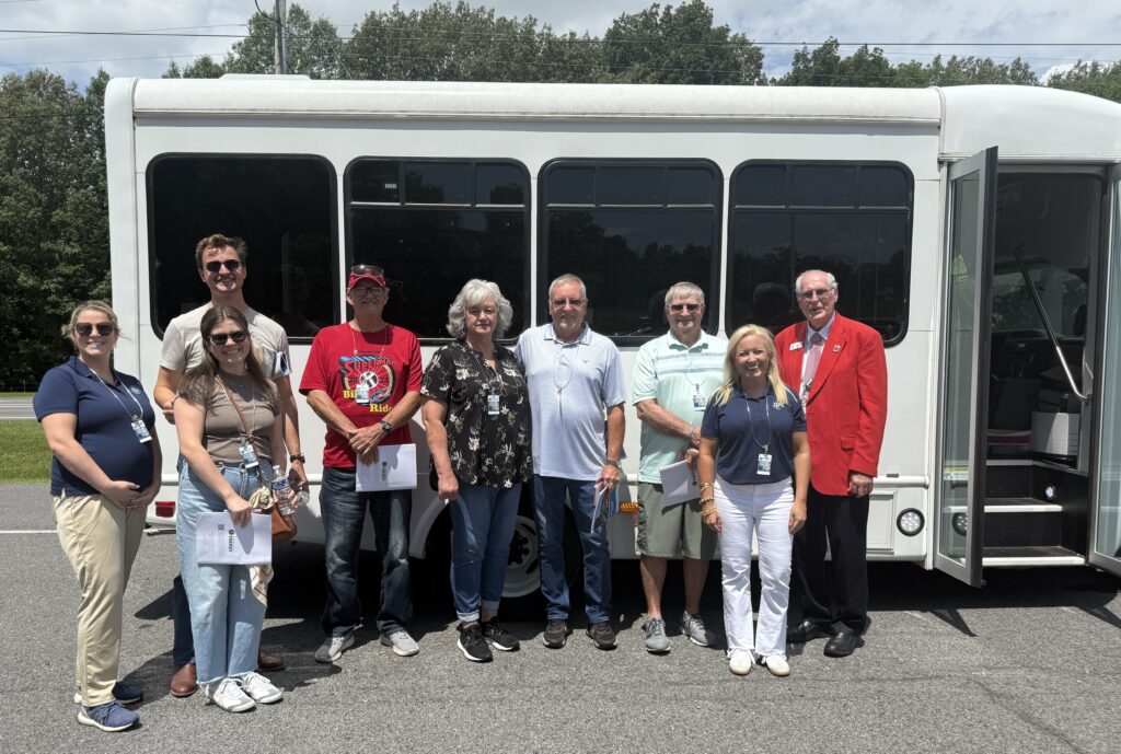 group of people standing in front of a bus